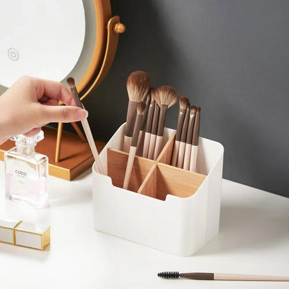 Main se servant dans un organiseur de bureau contenant des pinceaux de maquillage.